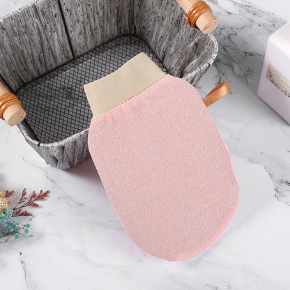 Pink Exfoliating Glove with beige top on a marble surface