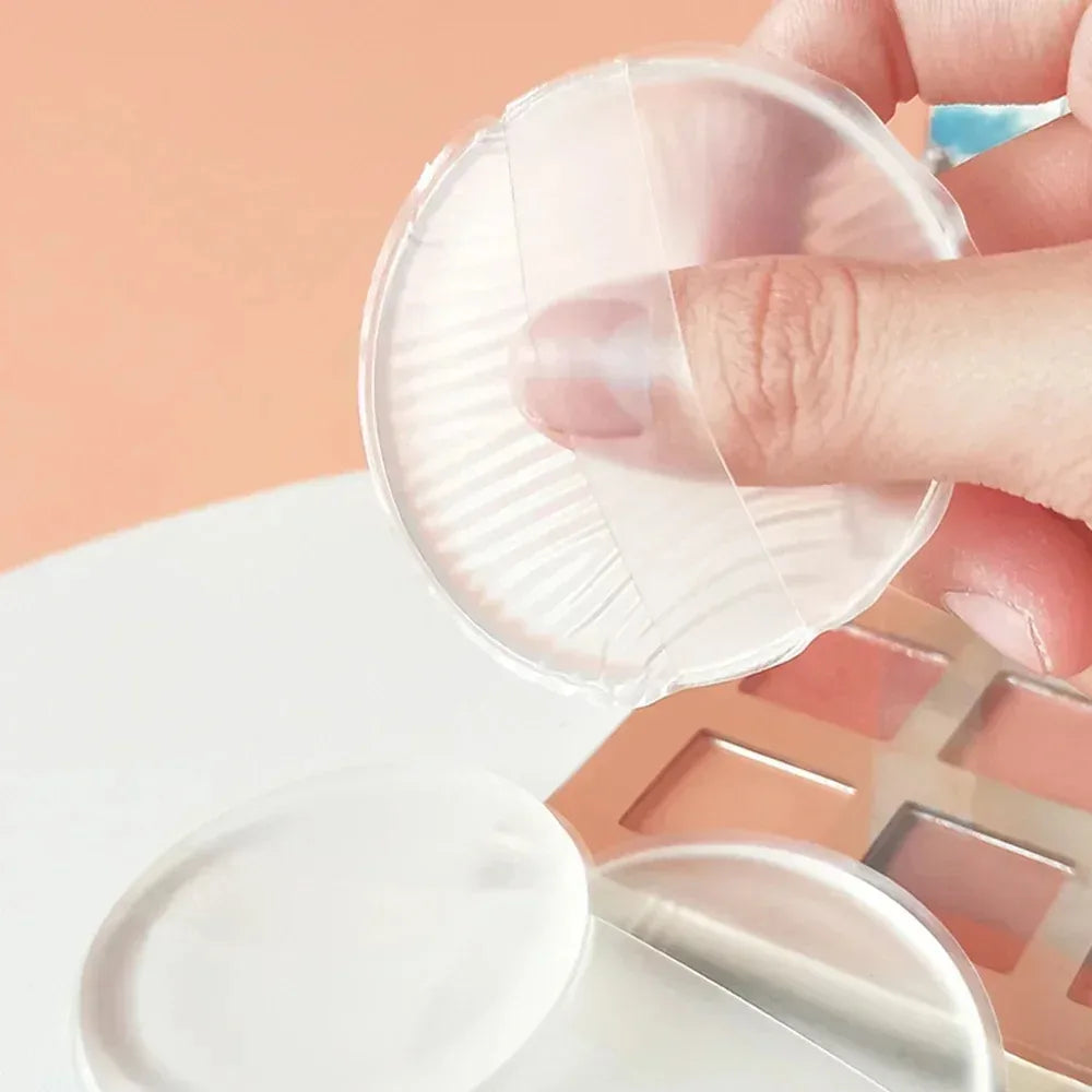 Hand holding a clear Silicone Powder Puff container with a pink background