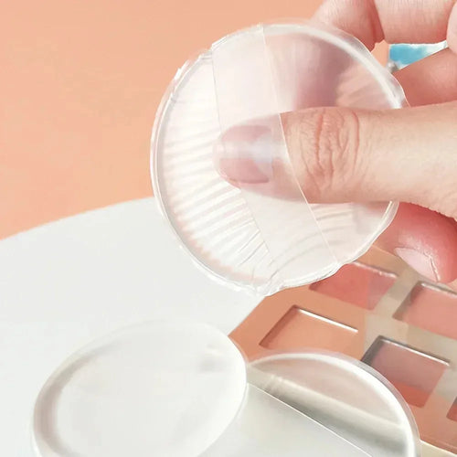 Hand holding a clear Silicone Powder Puff container with a pink background