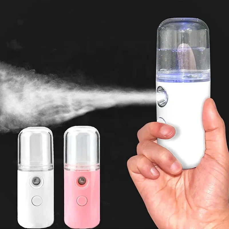 Handheld Facial Humidifier Mist device with steam, shown in white and pink, on a dark background.